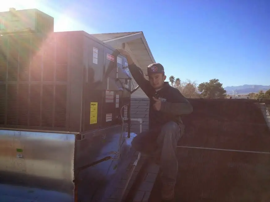HVAC technician performing Air Duct Cleaning on a rooftop unit in Stroud